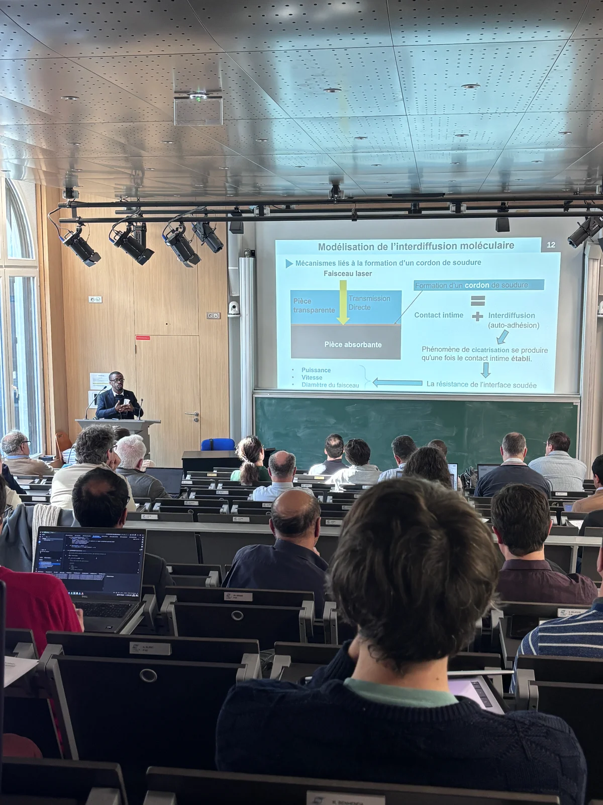 Présentation sur le soudage laser devant un public dans un amphithéâtre.
